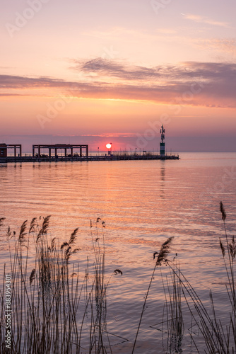 Sunrise on the shore and harbor of a lake in summer. Colorful sky with a wide view of the Horiont. Nature landscape at Tihany marina, Balaton, Lake Balaton, Siófok, Hungary