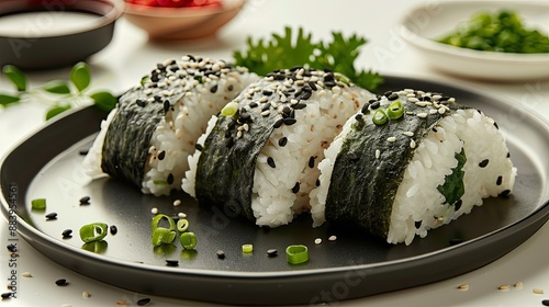 Onigiri with accompaniments in a black plate, looks delicious on a clean white table background, typical Japanese food.