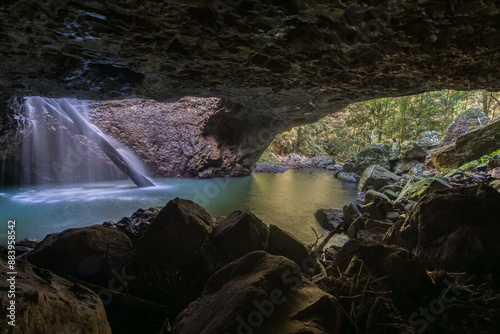Inside the cave at Natural Bridge in Springbrook National Park, Australia. Waterfall falls through the roof of a cave.