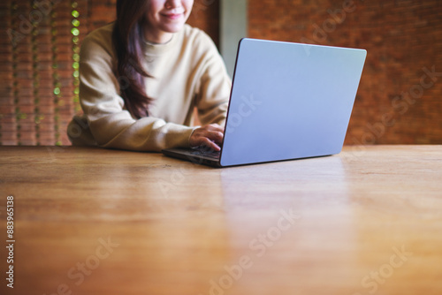 Closeup image of a young woman working on laptop computer