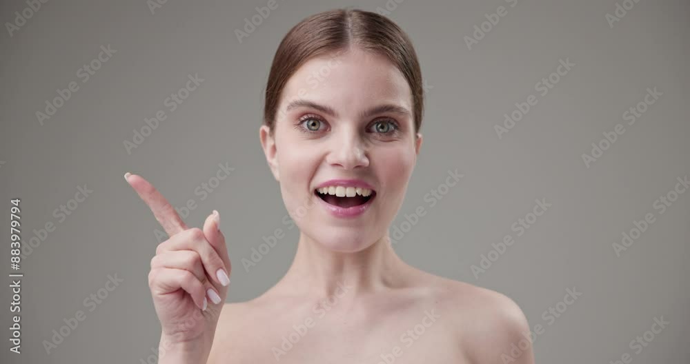 Beauty, health, cosmetics, anti-aging therapy and skin care concept - young beautiful brunette Caucasian woman looking at camera with wide eyes raising index finger up, showing gesturing idea Beauty, health, cosmetics, anti-aging therapy and skin care concept - young beautiful brunette Caucasian woman looking at camera with wide eyes raising index finger up, showing gesturing idea