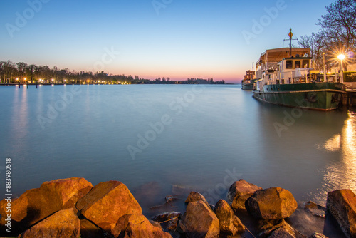 Sunrise on the shore and harbor of a lake in summer. Colorful sky with a wide view of the Horiont. Nature landscape at the marina of Balatonfüred Vitorláskikötő, Balaton, Lake Balaton, Siófok, Hungary photo