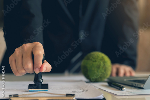 Business Hand Stamp With Approved Stamp On Document. validates and manages business documents agreements and approves Green business companies with eco-friendly waste management regulation concept.ESG