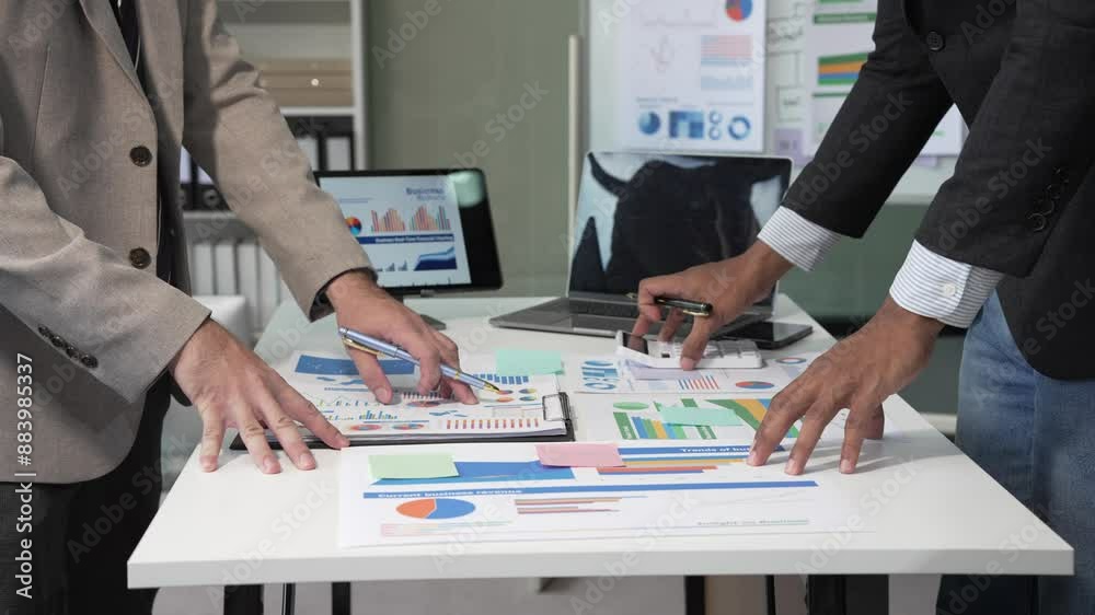 Collaborative meeting at the office desk on teamwork, discussions revolving around financial charts and the management of accounts in the production cost accounting system.