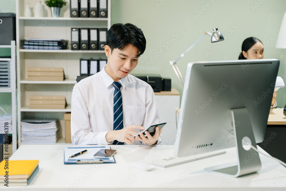 Young businessman working at office with laptop, tablet and taking notes on the paper.. Young businessman working at office with laptop, tablet and taking notes on the paper..