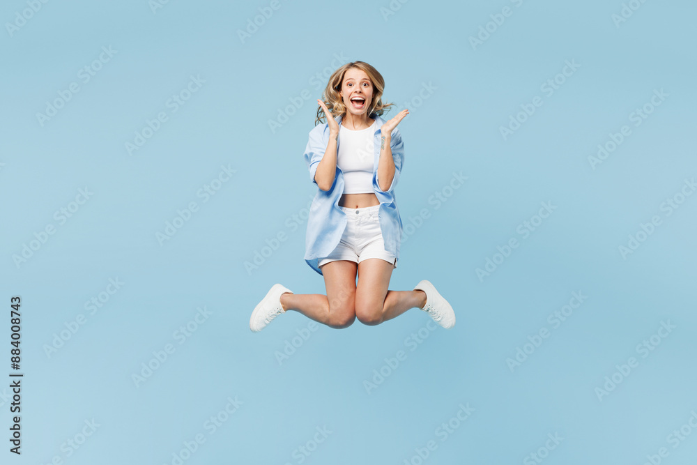 Full body young surprised shocked happy woman she wearing white top shirt casual clothes jump high spread hands isolated on plain pastel light blue cyan background studio portrait. Lifestyle concept. Full body young surprised shocked happy woman she wearing white top shirt casual clothes jump high spread hands isolated on plain pastel light blue cyan background studio portrait. Lifestyle concept.