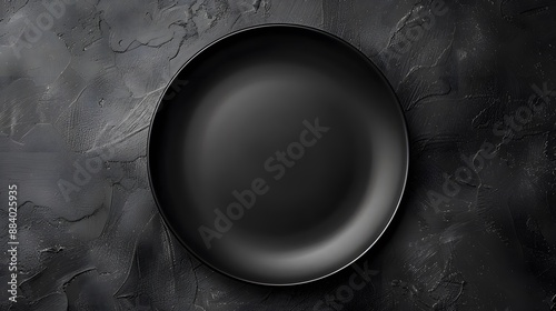 Black plate on a black background. Flat lay, top view, copy space