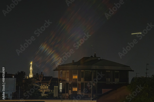 scia luminosa di notte con vista della madonnina di milano photo