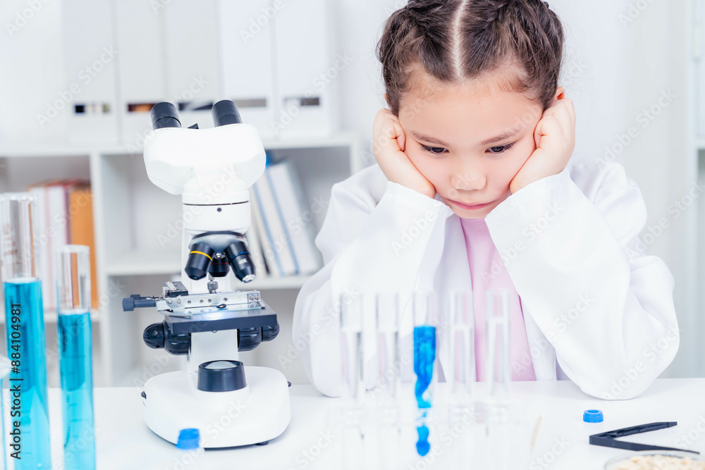 A young girl scientist failed in a scientific experiment Young girl in a lab coat looking thoughtfully at test tubes in a laboratory, embodying contemplation and dedication to scientific inquiry. A young girl scientist failed in a scientific experiment Young girl in a lab coat looking thoughtfully at test tubes in a laboratory, embodying contemplation and dedication to scientific inquiry.