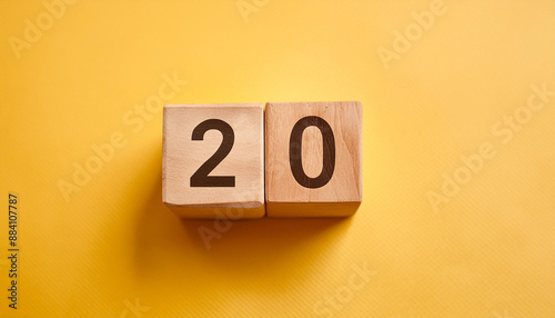 Wooden cubes with number 20 on isolated yellow backdrop. Wood blocks. Close-up. Flat lay