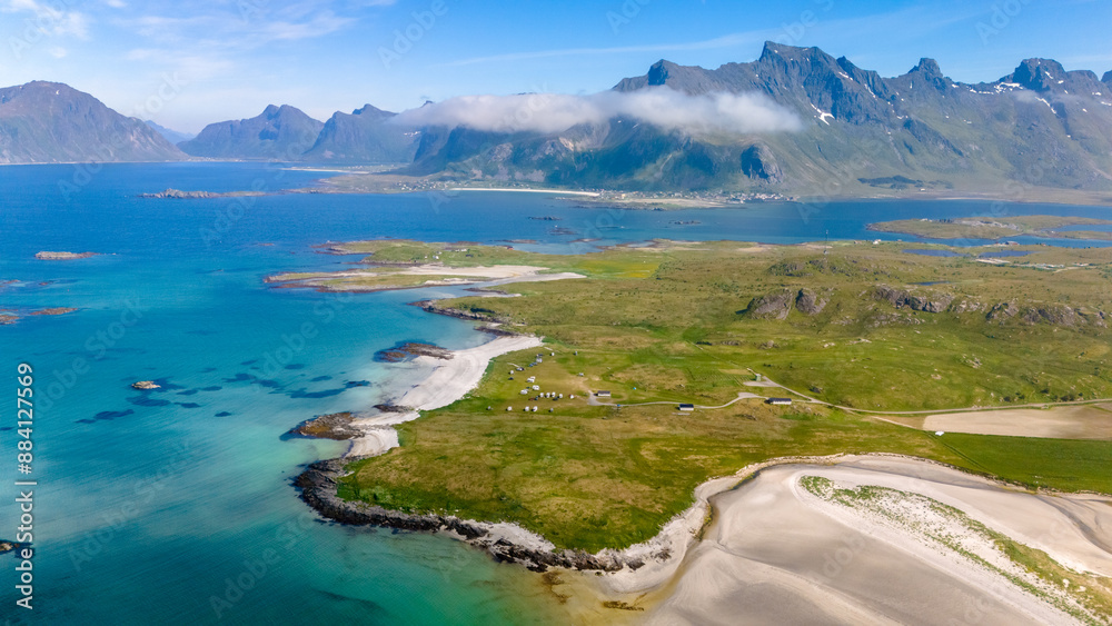 A tranquil Norwegian coastline with rolling green hills, pristine white sand beaches, and towering mountains reaching for the sky. Kolbeinsanden Beach, Lofoten A tranquil Norwegian coastline with rolling green hills, pristine white sand beaches, and towering mountains reaching for the sky. Kolbeinsanden Beach, Lofoten