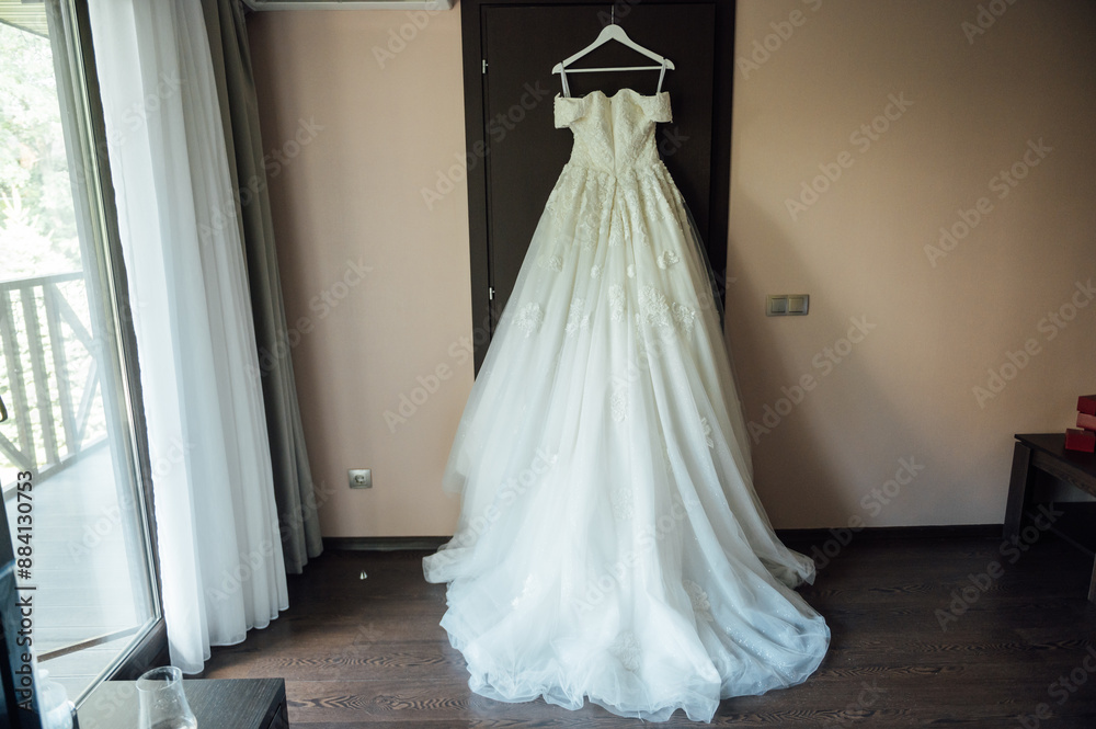 Wedding dress is hanging on the closet. Stylish photo Wedding dress is hanging on the closet. Stylish photo