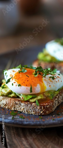 Close-up of a delicious avocado toast topped with a perfectly poached egg and sprinkled with fresh herbs, served on a rustic plate.