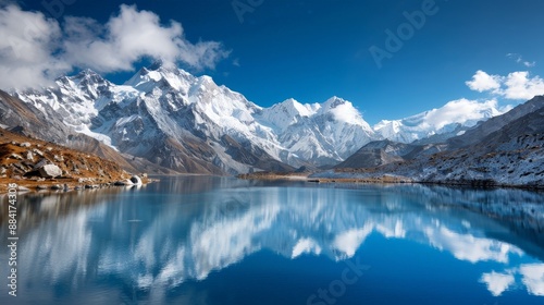 Breathtaking Snow-Capped Mountains Reflecting in a Serene Lake Under a Clear Blue Sky