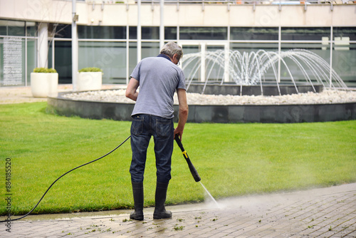 Worker the Sidewalk Cleaning with Water Jet