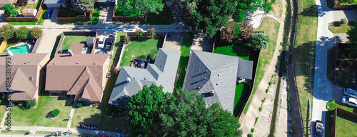 Row of large suburban houses with swimming pool, solar roof along concrete channels facilitates drainage from residential street discharge into creek in Coppell, Dallas Fort Worth complex, aerial photo