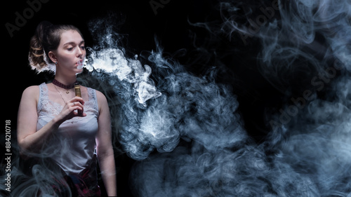 Woman smokes vape. Girl is ...