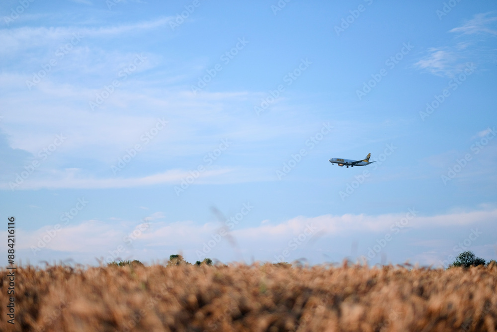 Poland, Europe - 10 07 2024: Buzz Low Cost Fares Airlines Aircraft Flying Before Landing Over Field with Hay Bales Poland, Europe - 10 07 2024: Buzz Low Cost Fares Airlines Aircraft Flying Before Landing Over Field with Hay Bales