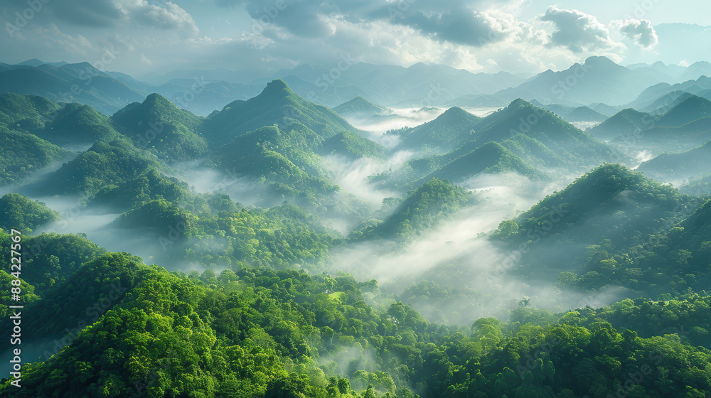 Obraz premium a beautiful landscape of misty mountains. The mountains are covered in lush green vegetation and the clouds are rolling in the valley below. 