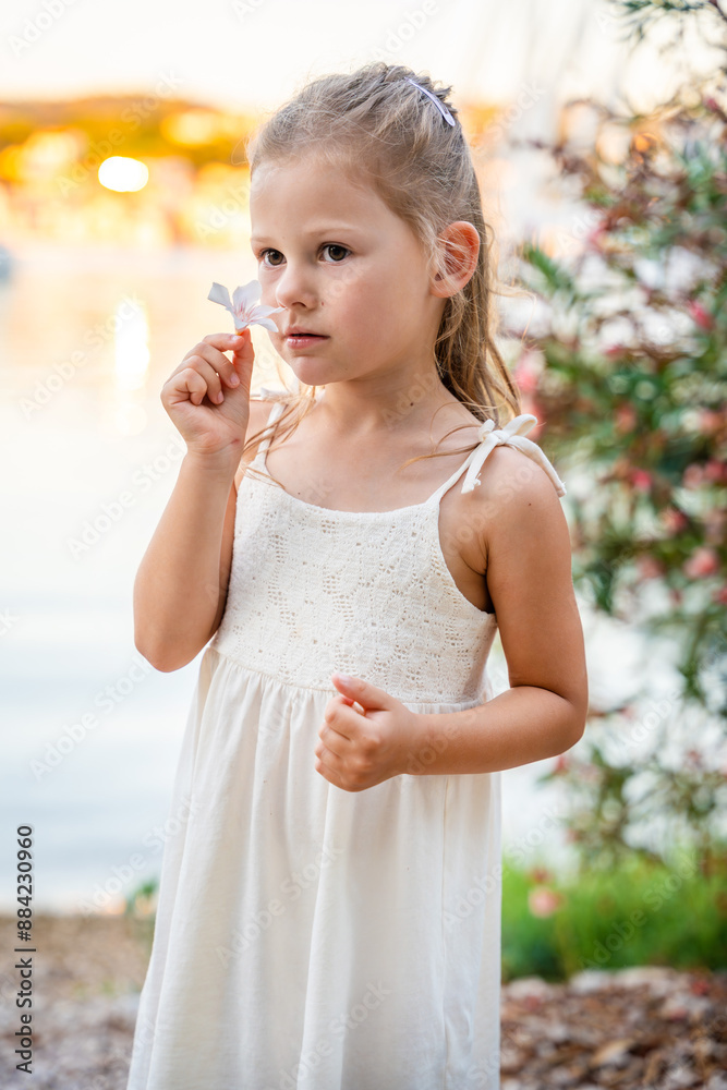 Portrait of little girl in white dress happy smiling on blooming park background in Croatia Portrait of little girl in white dress happy smiling on blooming park background in Croatia