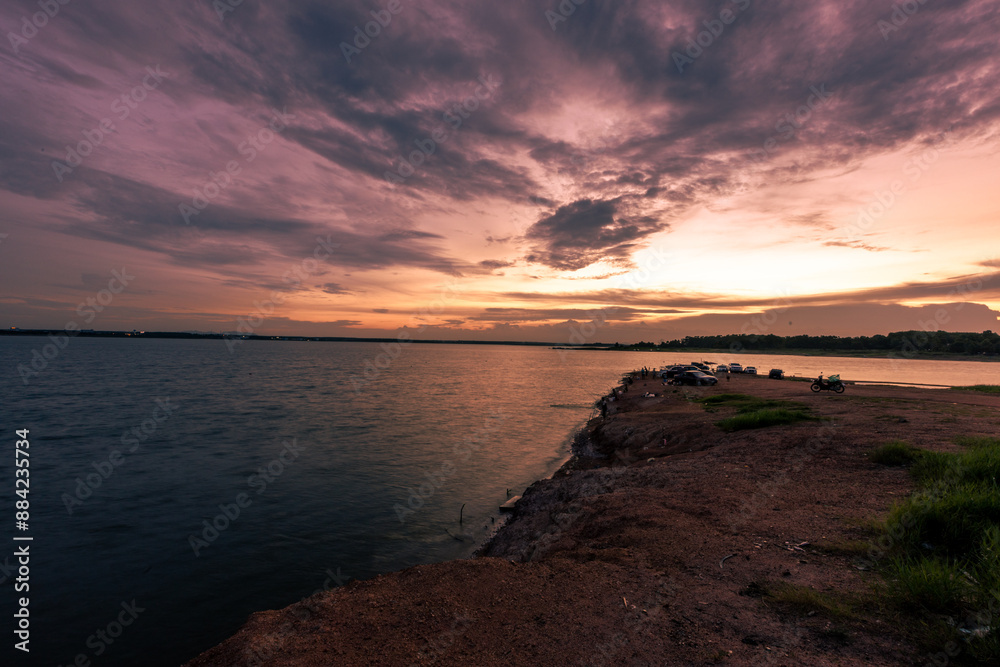Obraz premium The background of the sea by the evening sea, with natural beauty (sea water, rocks, sky) and fishermen are fishing by the river bank, is a pleasure during travel.
