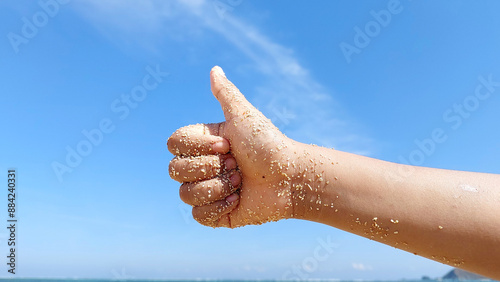 Thumb up hand sign isolated on blue sky background.