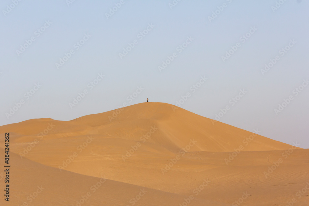 A man standing on top of a dune by himself indicating the concept of singlehood and loneliness. A man standing on top of a dune by himself indicating the concept of singlehood and loneliness.
