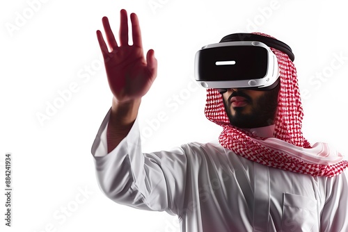 Saudi Gulf Arab man wearing a traditional white thobe and red shemagh, use VR virtual reality games on white background.