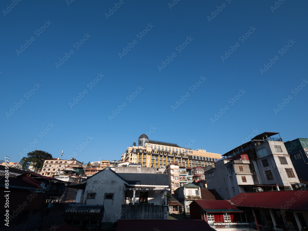Obraz premium Sun Plaza Yellow Building in Side View on a Clear Day behind The Blue Sky