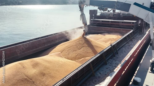  wheat loading in bulker ship cargo hold from silo in sea port. Trading and Transportation of agricultural commodities. photo