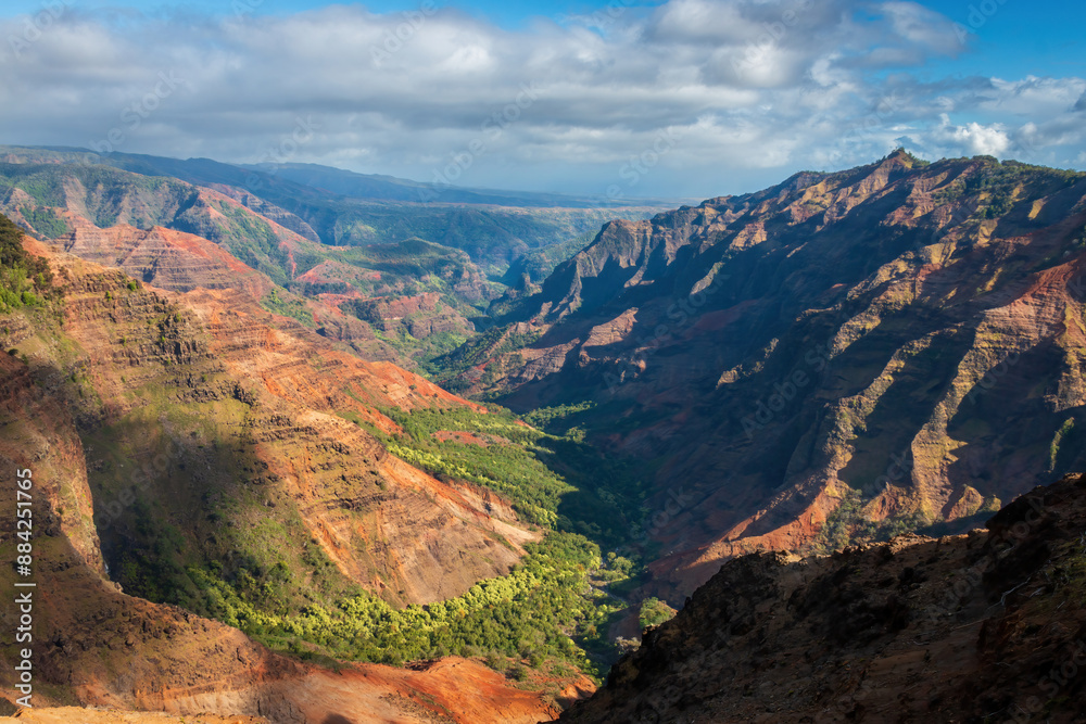 Panoramic view of Waimea Canyon on the Hawaiian island of Kauai, USA against blue sky with clouds