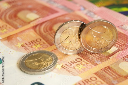 Business and finance. New 2 euro coins on euro banknotes. photo