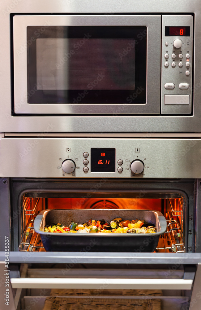 kitchen convection oven and microwave with tray of roasted vegetables, kitchen convection oven and microwave with tray of roasted vegetables,