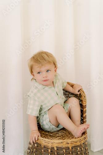 Cuadro en lienzo little boy sitting on a  wicker chair