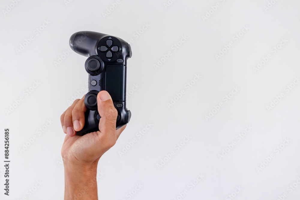 Hand holding a gamepad controller or joystick on a white background Hand holding a gamepad controller or joystick on a white background