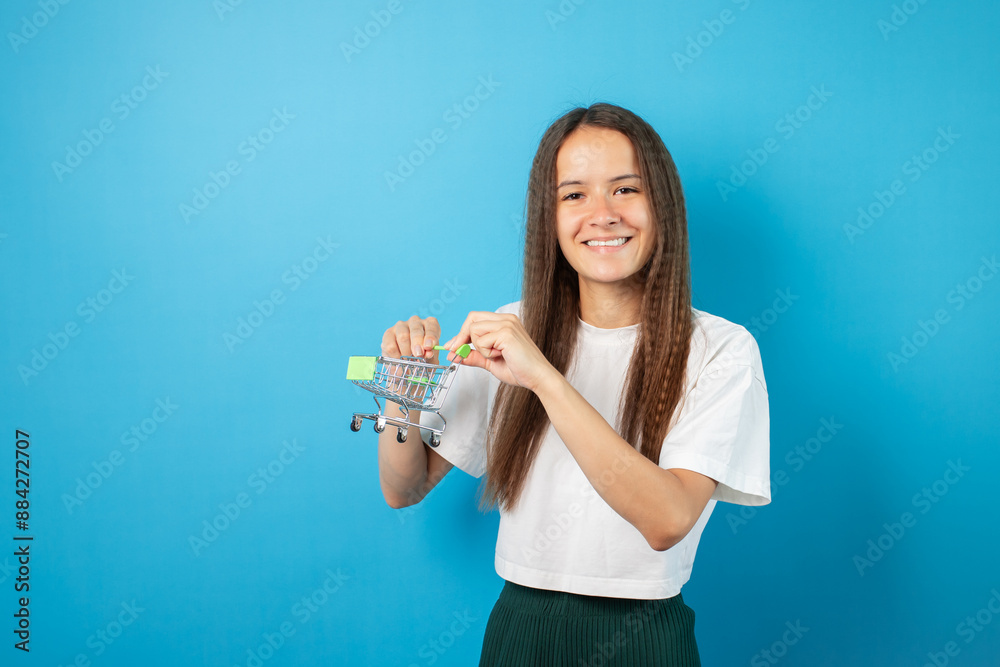 Grocery online, teenage girl with supermarket basket, student buys products online,shopping cart delivery service Grocery online, teenage girl with supermarket basket, student buys products online,shopping cart delivery service