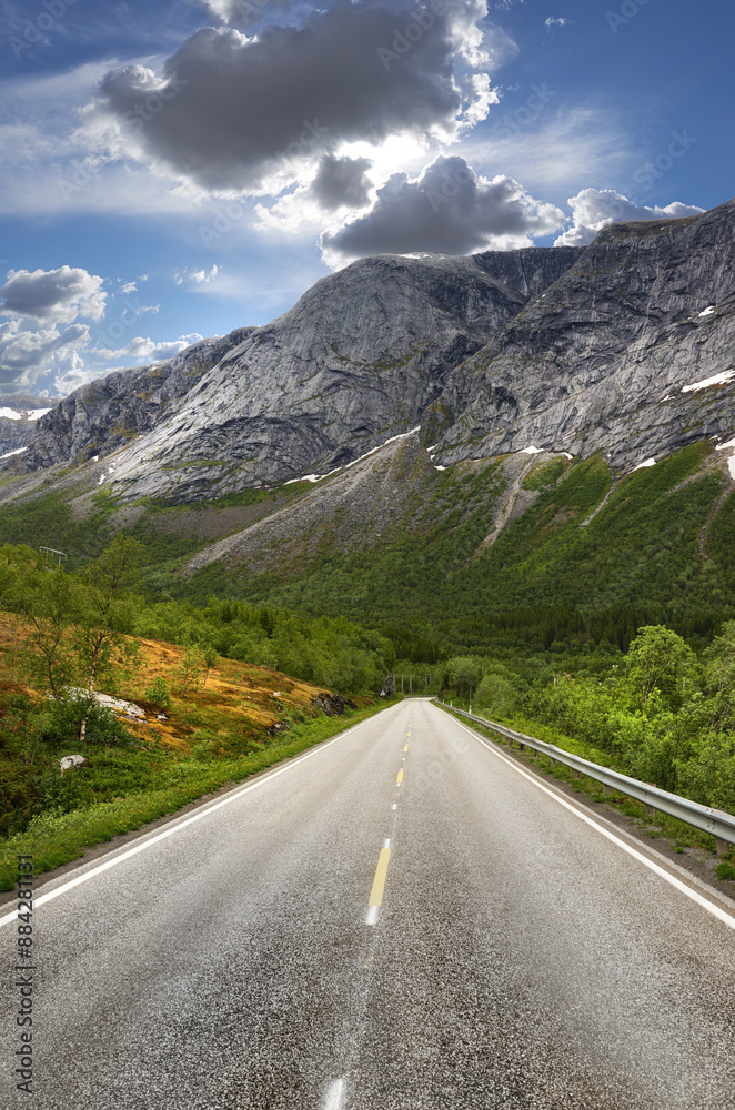 Naklejka premium Road, mountains and landscape for travel, journey and tourism with snow melting for start of spring. Environment, nature and secluded street for getaway, transport and holiday or vacation in Norway