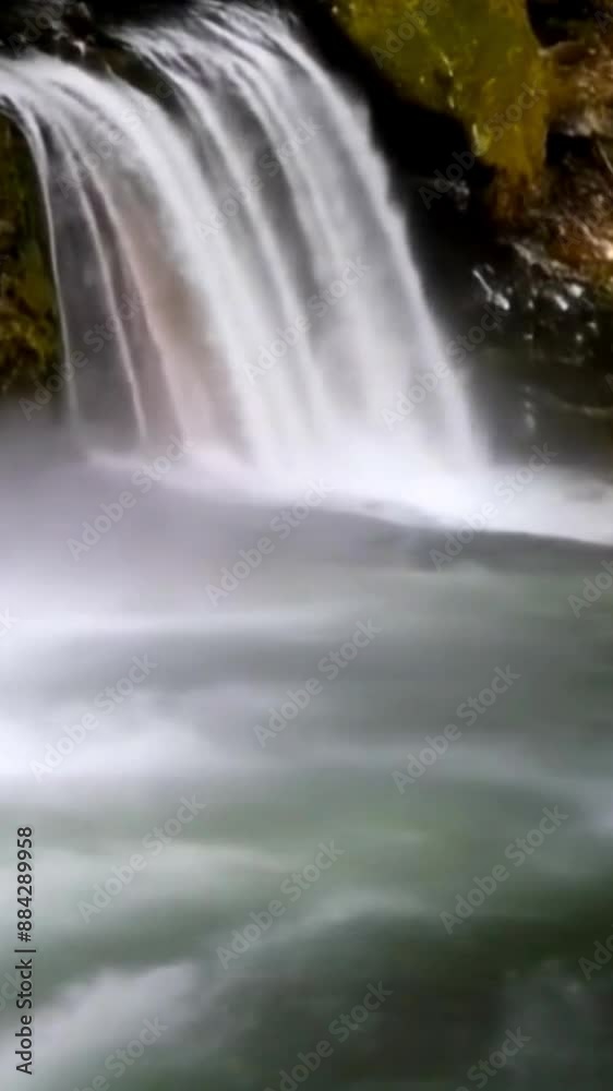 Beautiful waterfall with splashes and rainbow glow. Vertical Beautiful waterfall with splashes and rainbow glow. Vertical