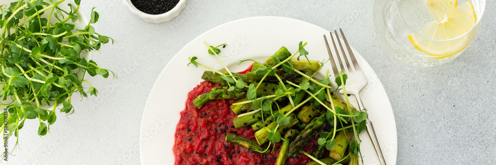 Beetroot risotto with rice and sesame seeds, baked asparagus with pea microgreens, banner Beetroot risotto with rice and sesame seeds, baked asparagus with pea microgreens, banner