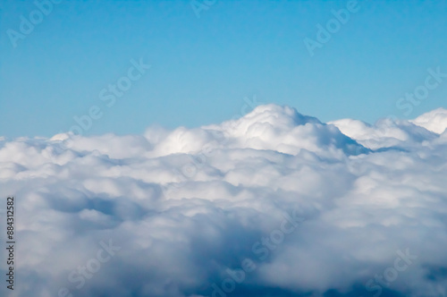 Nubes blancas algodonosas vistas en su parte superior desde un avión. Paisaje nublado a 12000 metros de altitud. Volando por encima de las nubes. photo