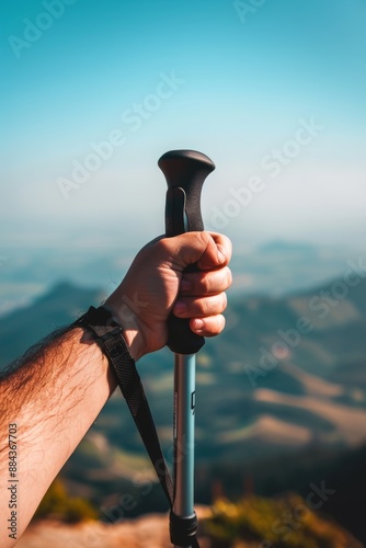 Hiker s hand gripping trekking pole with majestic mountains in the distant background