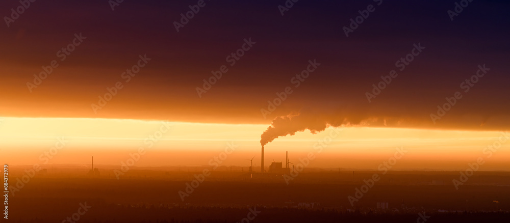 Fototapeta premium Sunrise over Industrial Factory Emitting Smoke, Stunning Contrast of Natural and Polluted Sky