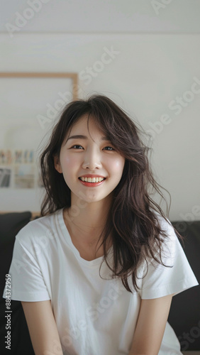 A striking portrait of a young Asian woman wearing an white t-shirt, exuding natural beauty and contemporary style.