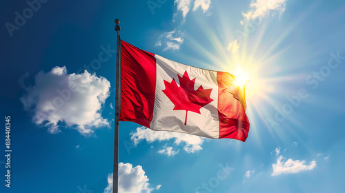 Canadian flag is flying high in the sky, with bright sunlight shining on it