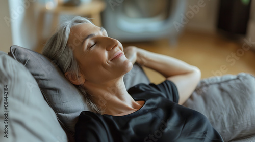 Mujer madura sonriendo descansando en el sofá