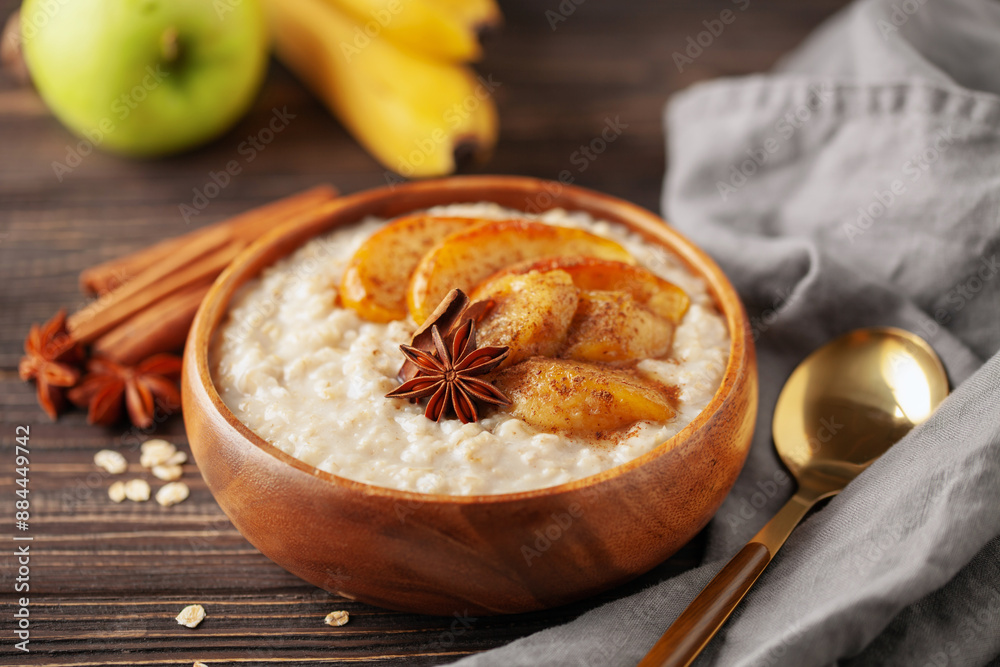 Oatmeal porridge with caramelised apples and bananas in bowl on the table. Homemade healthy breakfast Oatmeal porridge with caramelised apples and bananas in bowl on the table. Homemade healthy breakfast