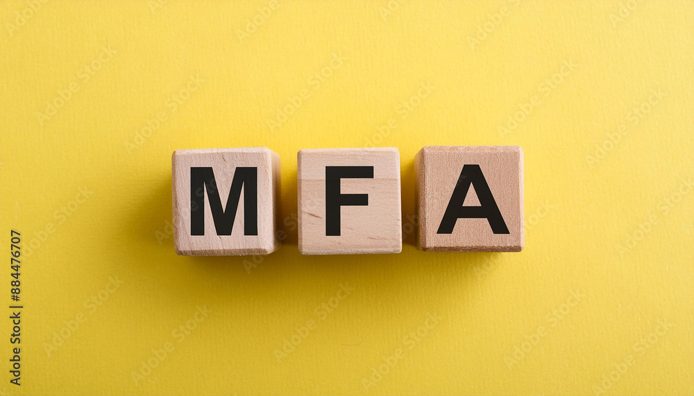 Obraz premium Wooden cubes with abbreviation MFA, yellow background. Multi-Factor Authentication. Online security