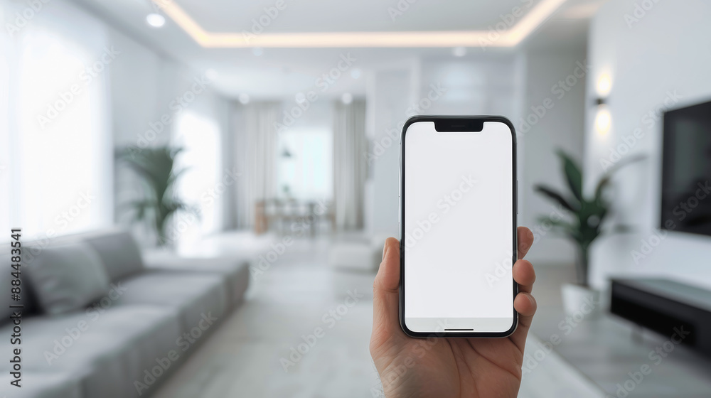 Hand holding a smartphone with blank screen in a modern living room. Hand holding a smartphone with blank screen in a modern living room.