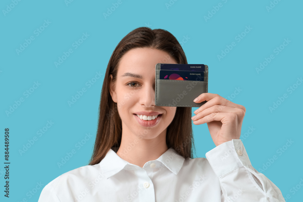 Woman with credit card holder on blue background Woman with credit card holder on blue background