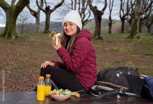 mountaineer woman eating banana in the autumn forest